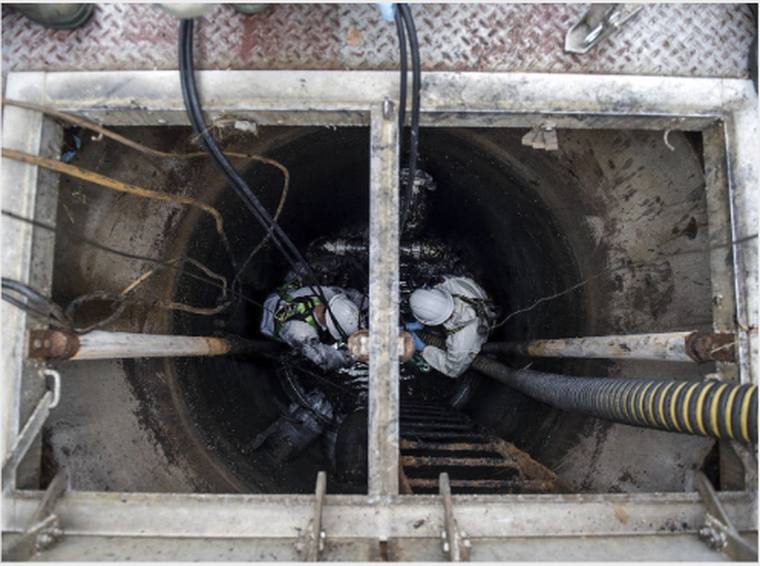 Crew working inside an open lift station wet well